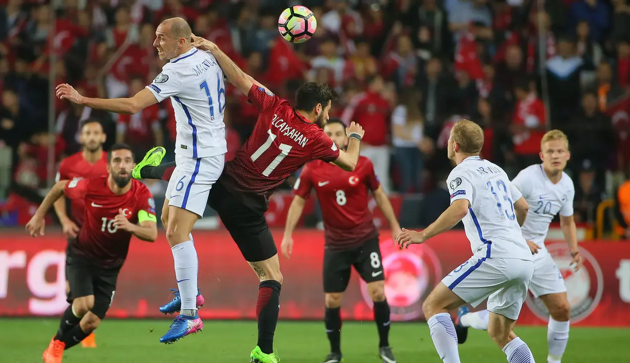 Gelandang Turki, Arda Turan, duel udara dengan bek Finlandia, Jere Uronen pada laga kualifikasi Piala Dunia 2018. Bermain di kandang klub asuhan Fatih Terim tersebut tampil menyerang untuk mendapatkan hasil positif. (AFP/Stringer)