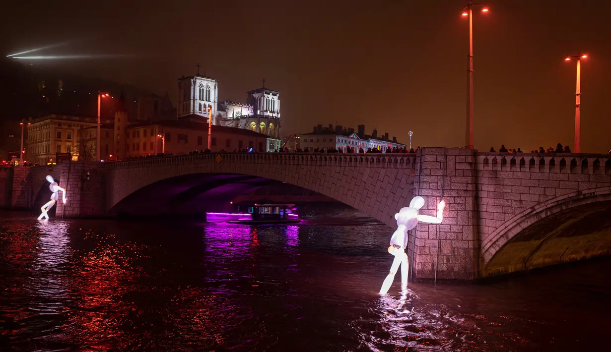 Instalasi cahaya terlihat di sebelah jembatan Bonaparte di atas sungai Saone selama Festival of Lights (Fete des Lumieres) di kota Lyon, Prancis, Kamis (5/12/2019). Festival Cahaya ini merupakan salah satu kegiatan yang paling terkenal di Lyon. (ROMAIN LAFABREGUE / AFP)