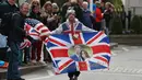 Warga mengibarkan bendera Inggris disertai gambar Pangeran Harry dan Meghan Markle setelah usai keduanya melahirkan anak pertama mereka di London, Inggris, Senin (6/5/2019). Warga pun bersuka cita atas kedatang anak berjenis kelamin laki-laki tersebut. (Dominic Lipinski/PA via AP)
