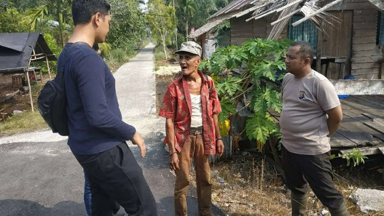 Polisi berbincang dengan kakek terduga pembakar lahan sebelum dibawa ke Polsek.