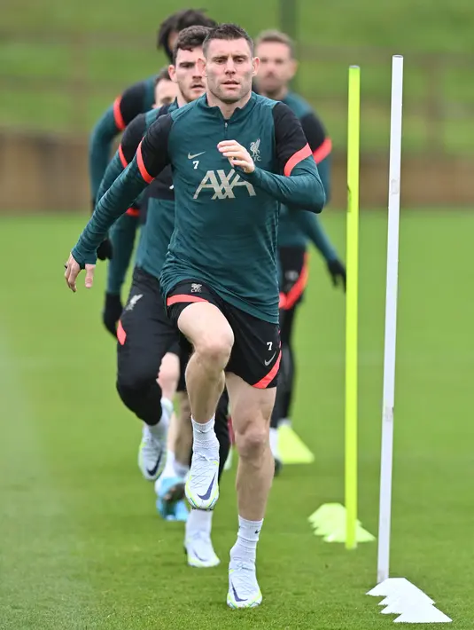 Gelandang Liverpool, James Milner bersama rekan setimnya melakukan pemanasan dalam sesi latihan di tempat latihan Liverpool FC di Liverpool, Inggris (4/4/2022). Liverpool akan bertanding melawan Benfica pada leg pertama perempat final Liga Champions di Estadio Da Luz, Portugal. (AFP/Paul Ellis)