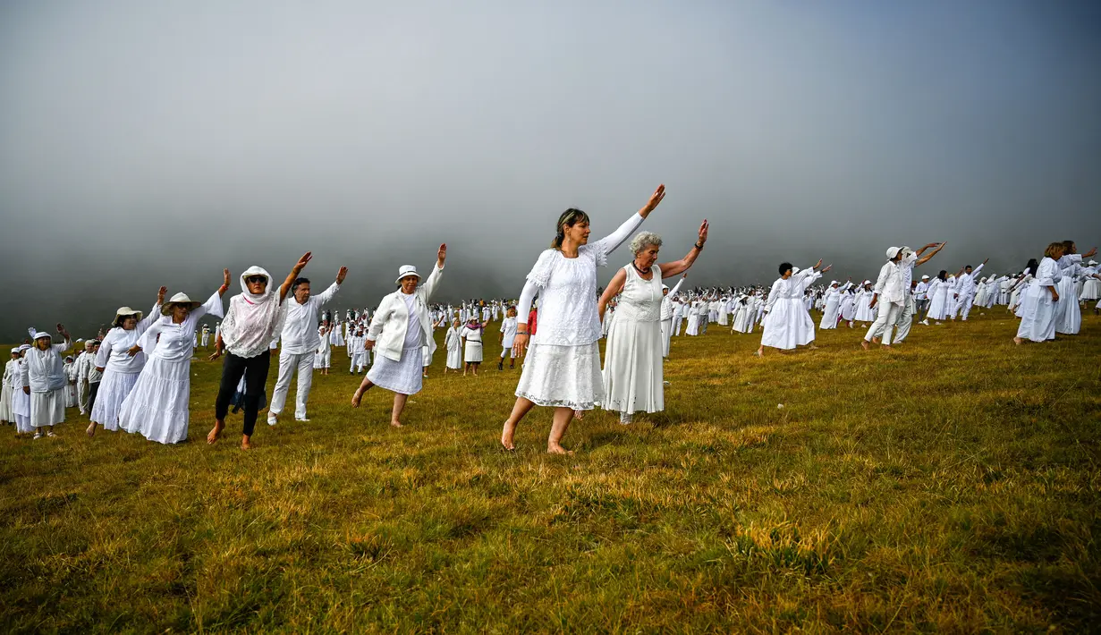 Anggota gerakan keagamaan internasional Persaudaraan Putih melakukan ritual tarian di puncak Gunung Rila, dekat Danau Babreka, Bulgaria, 19 Agustus 2021. Para penari berpakaian serba putih mendaki ke Danau Tujuh Rila pada ketinggian 2.100 meter (6.900 kaki). (NIKOLAY DOYCHINOV/AFP)