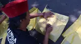 Salah satu warga membantu menuliskan nama Nina Carolina atau yang akrab dikenal dengan panggilan Mpok Alpa sesaat sebelum jenazah tiba di rumah duka, kawasan Ciganjur, Jakarta pada Jumat Jumat (15/8/2025). (KapanLagi.com/Budy Santoso)