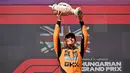 Pembalap McLaren, Lando Norris mengangkat trofi juara saat merayakan kemenangan dalam ajang balap Formula 1 GP Hungaria 2025 di sirkuit Hongaroring, Minggu (03/08/2025) waktu setempat. (AFP/Attila Kisbenedek)