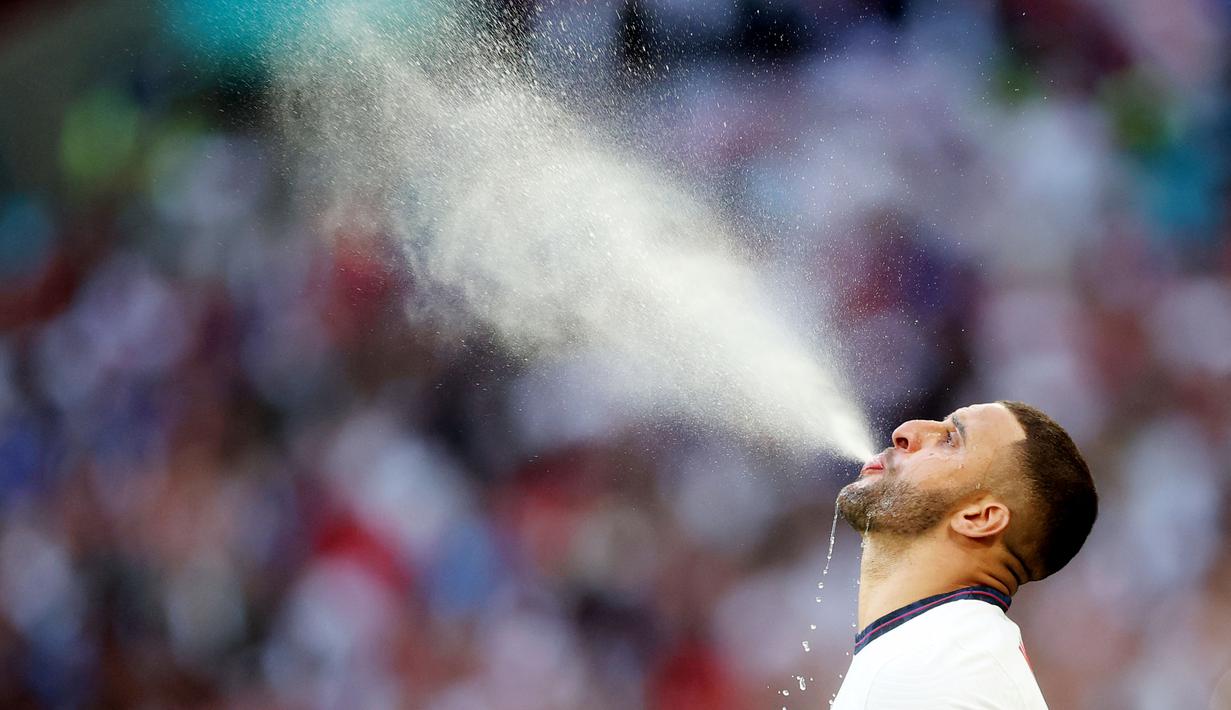 Bek Timnas Inggris, Kyle Walker, menyemburkan air saat pertandingan melawan Denmark pada laga semifinal Euro 2020 di Stadion Wembley, Kamis (8/7/2021). (Foto:AFP/Carl Recine,Pool)
