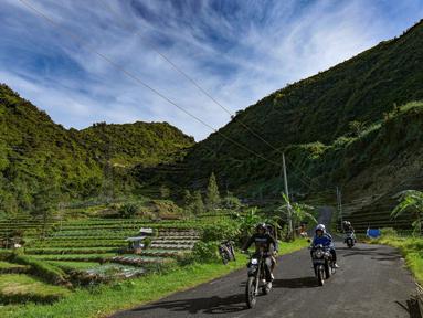 Warga melintasi kawasan pegunungan yang dijuluki "Swiss van Java" di sekitar Desa Wisata Sembungan, Wonosobo, Jawa Tengah, Senin (7/4/2025). (merdeka.com/Arie Basuki