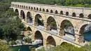 Pemandangan Pont du Gard atau Jembatan Gard di Vers-Pont-du-Gard, Prancis, Rabu (21/8/2019). Dahulu , Pont du Gard digunakan untuk memenuhi kebutuhan air Romawi di Nimes (bernama Nemausus pada zaman Romawi) dari Uzes. (Pascal GUYOT/AFP)