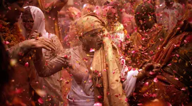 Para janda menari dan saling melempar serbuk berwarna dan kembang saat mengikuti tradisi perayaan Holi di Vrindavan, Uttar Pradesh, India (21/3). Holi merupakan salah satu festival perayaan awal musim semi terbesar di India. (REUTERS/Anindito Mukherjee)