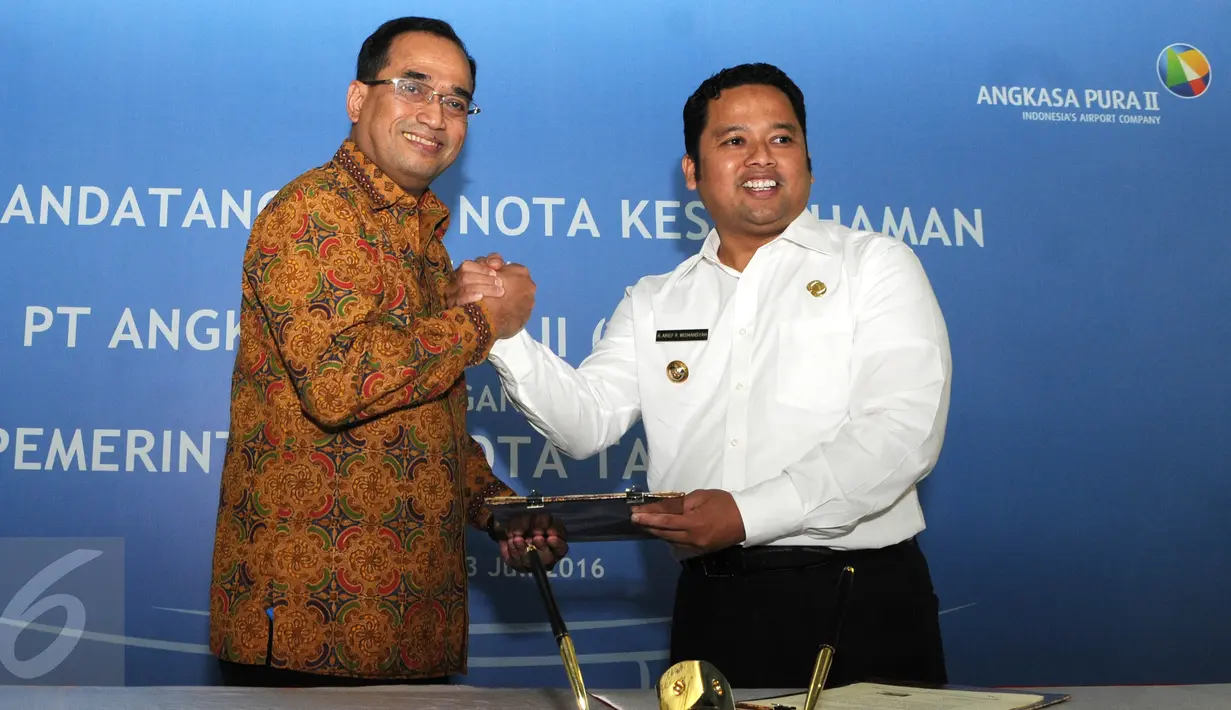 Presdir AP II, Budi Karya Sumadi dan Walikota Tangerang Arief R Wismansyah berjabat tangan usai penandatanganan nota kesepahaman mengenai suplai air bersih dan siap minum di Bandara Soekarno-Hatta, Tangerang, Rabu (13/7). (Liputan6.com/Helmi Affandi)