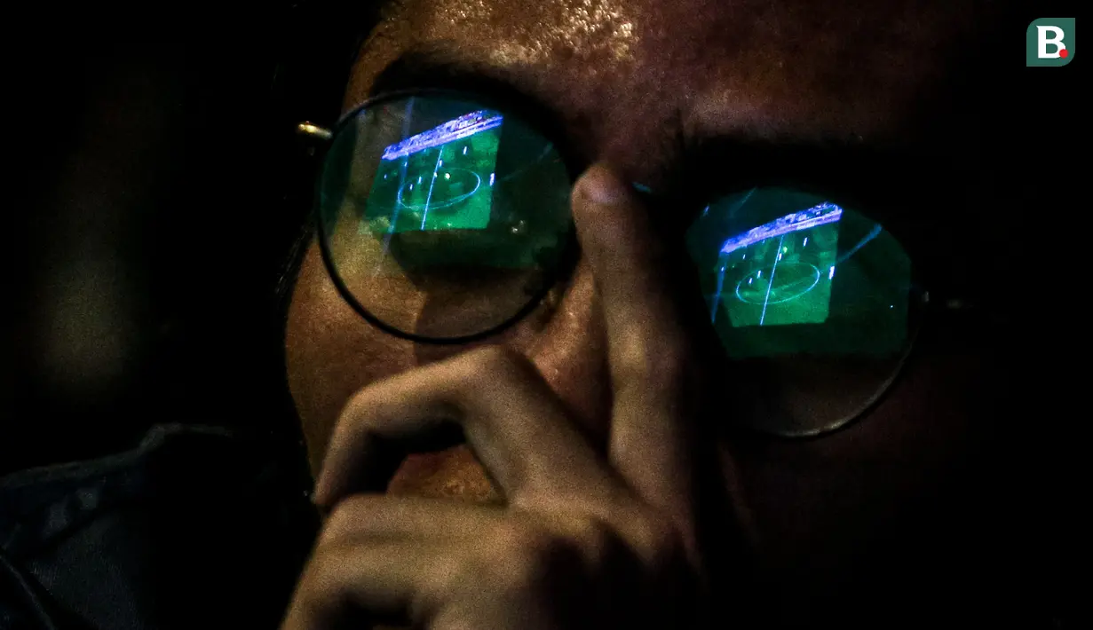 Refleksi tampilan pertandingan pada layar di kacamata seorang penonton ketika nonton bareng Timnas Indonesia U-23 melawan Uzbekistan U-23 pada laga semifinal Piala Asia U-23 di Kompleks Stadion Utama Gelora Bung Karno (SUGBK), Senayan, Jakarta, Senin (29/04/2024) malam WIB. (Bola.com/Bagaskara Lazuardi)