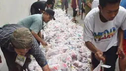 Panitia menata plastik berisi daging kurban untuk dibagikan kepada warga di jalan Kauman Semarang,Jawa Tengah, Senin (12/9). Panitia kurban membagikan lebih dari 5.000 paket daging kepada warga. (Liputan6.com/Gholib)