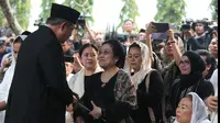Presiden ke-6 RI Susilo Bambang Yudhoyono bersalaman dengan Presiden ke-5 RI Megawati Soekarnoputri usai prosesi pemakaman Ani Yudhoyono di TMP Kalibata, Jakarta, Minggu (2/6/2019). Megawati duduk bersebelahan dengan Ibu Negara Iriana Joko Widodo dan Sinta Nuriyah Wahid. (Liputan6.com/HO/Rangga)
