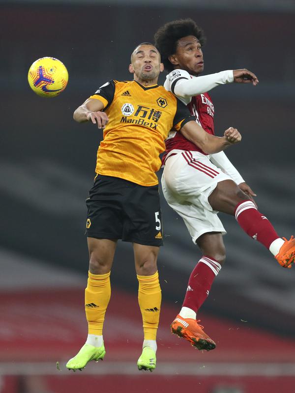 Bek Wolverhampton Wanderers, Fernando Marcal berebut bola dengan penyerang Arsenal, Willian l pada pekan kesepuluh Liga Inggris di Emirates Stadium, London, Minggu (29/11/2020). Arsenal takluk 1-2 dari Wolverhampton Wanderers. (Catherine Ivill/Pool via AP)