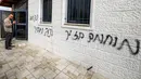 Para pemukim ilegal Israel juga mencoret dinding Masjid Abu Bakr as-Siddiq yang berada di antara Sarra dan Tal, dekat Nablus, wilayah utara Tepi Barat, dengan slogan-slogan rasis. Tampak dalam foto, seorang pria merekam coretan grafiti Ibrani pada dinding luar Masjid Abu Bakr al-Siddiq di desa Tell, sebelah barat Nablus, Tepi Barat yang diduduki, pada 23 Februari 2026. (JAAFAR ASHTIYEH/AFP)