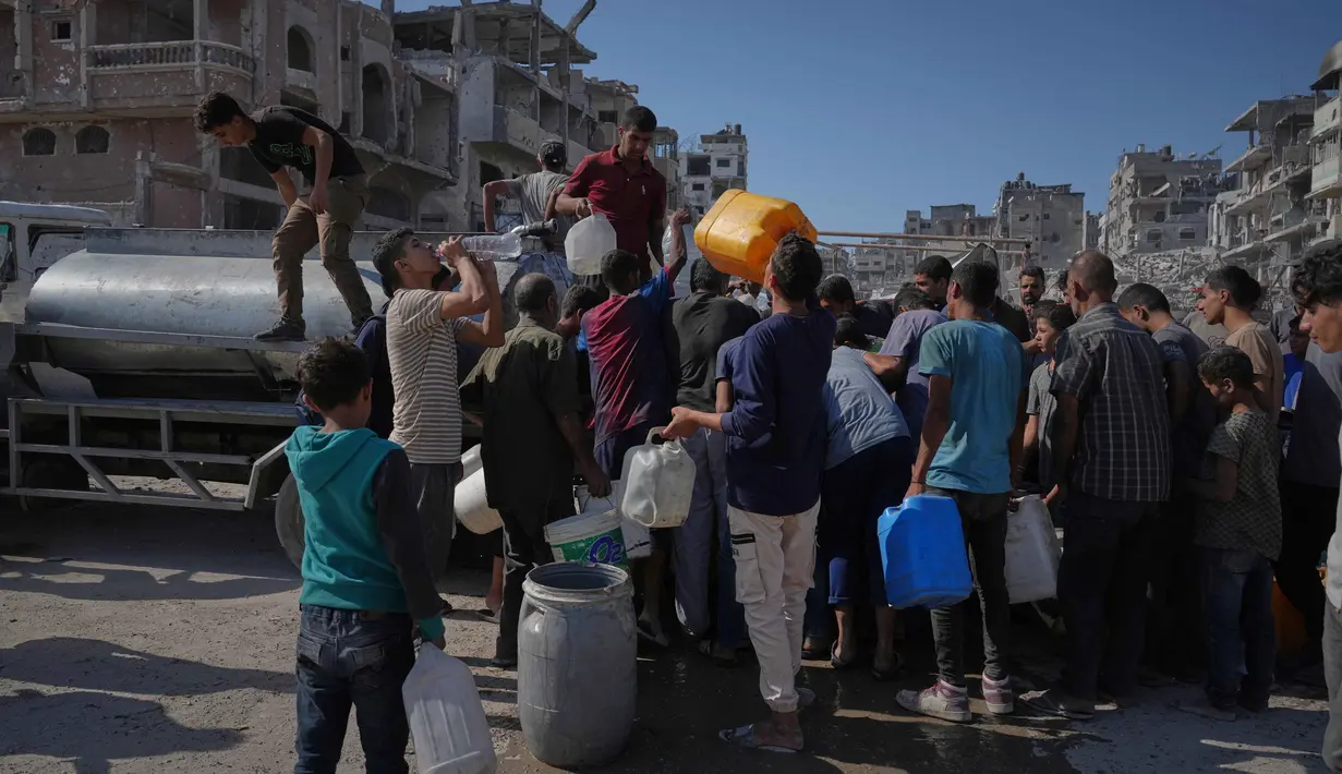 Warga, termasuk anak-anak, sering kali harus mengantre berjam-jam untuk mendapatkan air. Jumlah air yang didapat pun sangat terbatas, jauh dari cukup untuk kebutuhan normal. (AP Photo/Jehad Alshrafi)