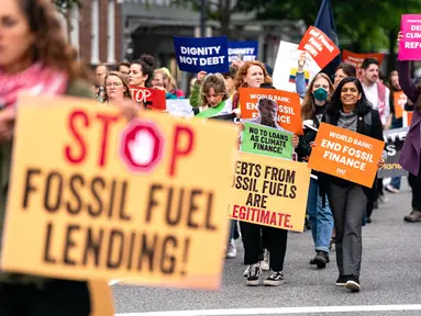 Para pengunjuk rasa berjalan kaki sambil melakukan aksi protes di sekitar lokasi Pertemuan Musim Semi IMF-Bank Dunia di Pennsylvania Ave menuju gedung International Finance Corporation pada 19 April 2024 di Washington DC. (Kent Nishimura/Getty Images North America/Getty Images via AFP)