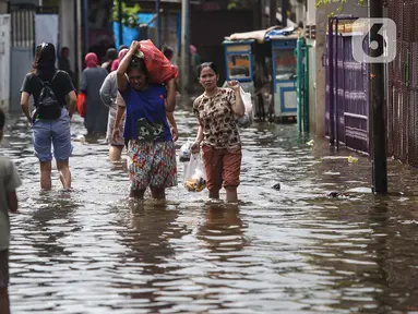 Warga melintasi banjir di salah satu permukiman penduduk di Kawasan Cengkareng Barat, Jakarta Barat, Kamis (30/1/2025). (Liputan6.com/Angga Yuniar)