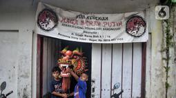 Anak-anak berpose memegang Liong di depan tempat latihan Naga Merah Putih di kawasan Babakan Pasar, Bogor, Jawa Barat, Senin (17/1/2022). Jelang perayaan Tahun Baru Imlek, klub kesenian Tionghoa tersebut rutin melakukan latihan memainkan Liong dan Barongsai. (merdeka.com/Iqbal S. Nugroho)