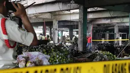 Saat ini, kebakaran yang menghanguskan kios buah di Pasar Induk Kramat Jati sudah berhasil dipadamkan. Sejumlah personel Damkar terus melakukan upaya pendinginan di lokasi. Tampak dalam foto, beberapa pedagang berupaya menyelamatkan sisa dagangannya setelah api yang membakar Pasar Induk Kramat Jati Jakarta berhasil dipadamkan pada Senin (15/12/2025). (merdeka.com/magang/Rendi Saputra)