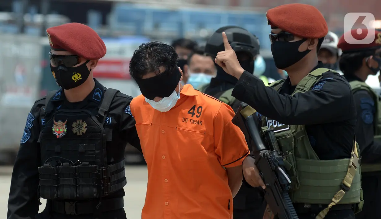 Mata terduga teroris ditutup saat digiring anggota Densus 88 Antiteror setibanya di Bandara Soekarno-Hatta, Tangerang, Banten, Kamis (18/3/2021). Polri memindahkan 22 terduga teroris jaringan kelompok Jamaah Islamiyah (JI) dari Jawa Timur ke Jakarta. (merdeka.com/Imam Buhori)