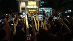  Suporter Manchester United mengambil foto pemain MU saat memasuki bus yang akan membawa ke bandar udara setelah pertandingan melawan Manchester City dibatalkan di Beijing, China. (25/7/2016). (AFP)
