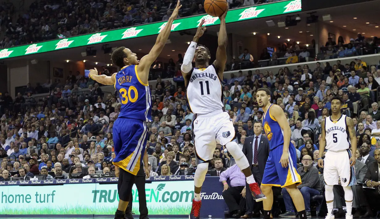 Pebasket Memphis Grizzlies Mike Conley (tengah) melakukan tembakan saat dikawal pebasket Golden State Warriors Stephen Curry di FedExForum, Memphis,Kamis (12/11/2015). Golden State kalahkan Memphis 100-84. (Reuters/Nelson Chenault-USA TODAY Sports)