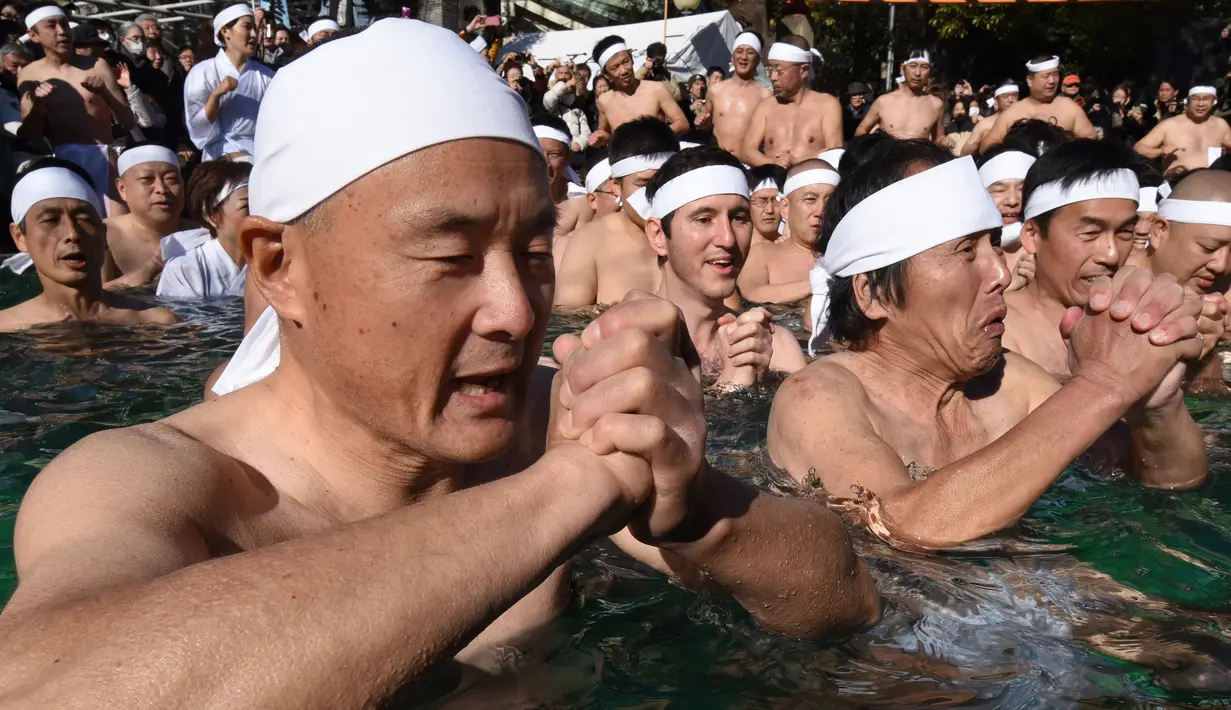 Penganut Shinto berdoa di kolam renang es untuk memurnikan tubuh dan jiwa dalam ritual Upacara Penyucian di Tokyo, Minggu (10/01/2016). (AFP Photo/ Toru Yamanaka)