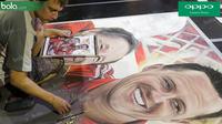 Seorang pelukis melukis wajah Michael Schumacher dan Jean Todt di salah satu stan merchandise F1 di kawasan Southbank, Melbourne, Australia, Jumat (18/3/2016). Seri perdana F1 akan digelar di Sirkuit Albert Park, Australia, Minggu (20/3/2016). (Bola.com/Y