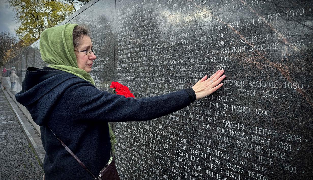 Seorang perempuan mengunjungi tugu peringatan bagi para korban represi politik di Butovo, di luar Moskow, pada Kamis 30 Oktober 2025, menandai hari peringatan. Untuk memperingati para korban represi politik, keluarga dan kerabat ramai-ramai berziarah di kompleks memorial yang didirikan di Lapangan Tembak Butovo, pinggiran selatan Moskow. (Nikita BORISSOV/AFP)