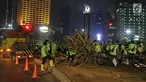 Petugas Dinas Kehutanan DKI Jakarta membongkar instalasi bambu Getah Getih di Bundaran Hotel Indonesia (HI), Kamis (18/7/2019) dini hari. Karya seni tersebut rencananya akan diganti dengan taman dan setelah dibongkar, bambu itu akan dibawa ke tempat pembuangan sampah. (Liputan6.com/Herman Zakharia)