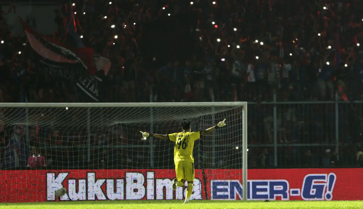 Kiper Arema FC, Kurniawan Ajie, merayakan gelar juara Piala Presiden 2019 usai menaklukkan Persebaya Surabaya di Stadion Kanjuruhan, Jumat (13/4). Arema FC menang 2-0 atas Persebaya. (Bola.com/Yoppy Renato)