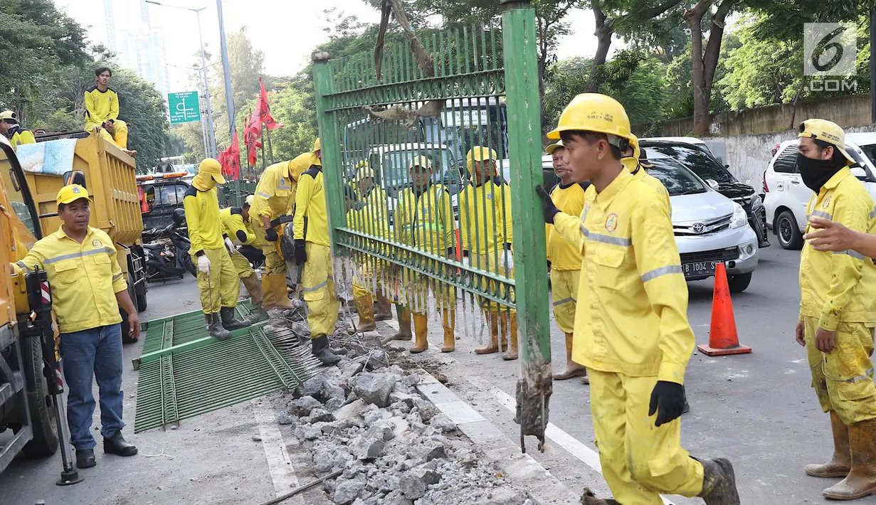 Petugas Dinas Bina Marga membongkar pagar dan sepatator di Jalan Galunggung, Jakarta, Kamis (10/1). Pembongkaran dilakukan guna menghilangkan batas antar jalur sehingga diharapkan dapat mengurai simpul kemacetan. (Liputan6.com/Immanuel Antonius)