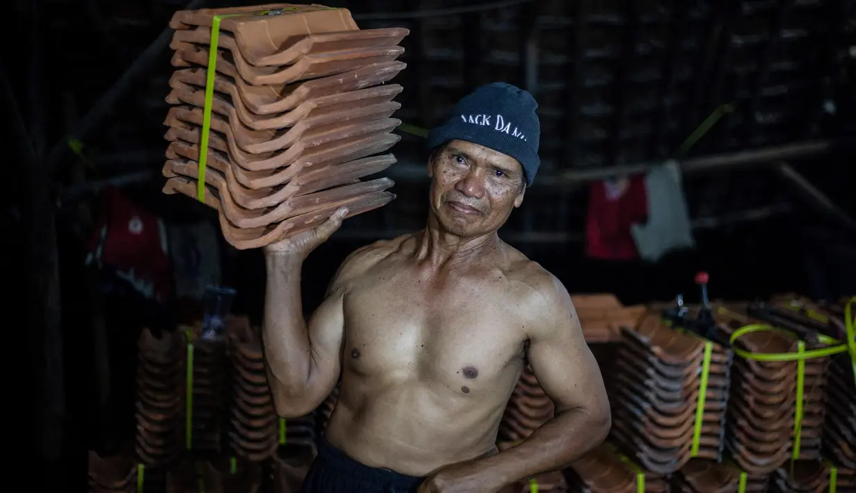 Mereka sehari-harinya bekerja memompa dan mengolah tanah liat menjadi produk genteng khas daerah mereka. (Aditya Irawan/AFP)