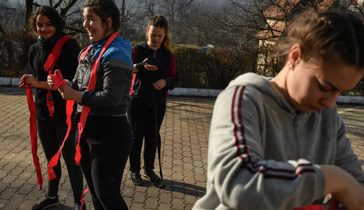 Petinju perempuan mengenakan sarung tinju mereka selama sesi pelatihan di kamp persiapan di Sarata Monteoru, sebuah kota kecil wisata di perbukitan Carpathians Timur di Rumania (14/1/2020). (AFP/Daniel Mihailescu)