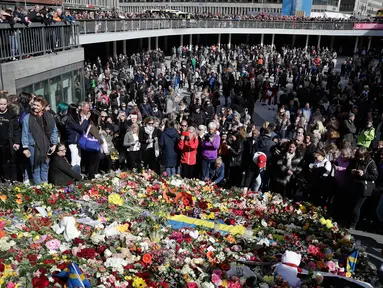 Orang-orang berkerumun di lokasi terjadinya serangan truk di Stockholm, Swedia, Minggu (9/4). Sebuah truk yang dibajak menabrakkan diri ke kerumunan pejalan kaki pada Sabtu (8/4) dan menewaskan empat orang. (AP Photo / Markus Schreiber)