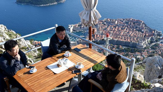 Wisatawan menikmati kopi dari puncak Bukit Srd menghadap ke kota tua Dubrovnik pada 28 Maret 2019. Tahun lalu lebih dari 1,2 juta turis mengunjungi Dubrovnik, kota yang paling banyak dikunjungi di Kroasia. (Denis LOVROVIC / AFP)