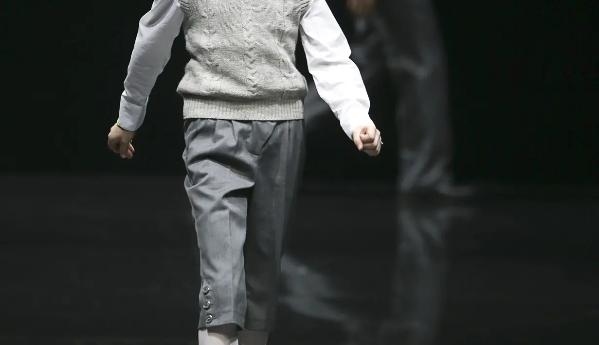 Model kecil ini tampak berjalan diatas catwalk dengan senyum misteriusnya di Moscow Fashion Week (REUTERS/Sergei Karpukhin)