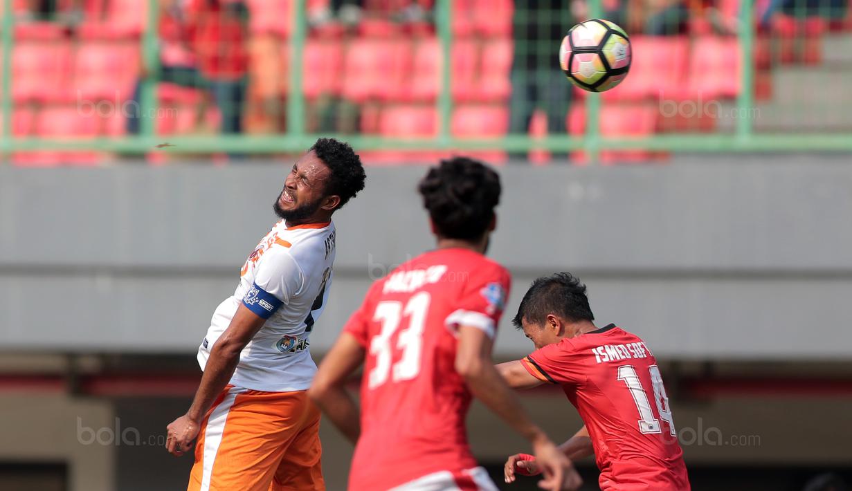Kapten Perseru Serui, Arthur Bonai (kiri) membuang bola dari kejaran pemain Persija Jakarta pada lanjutan Liga 1 2017 di Stadion Patriot Bekasi, Selasa (19/9/2017). Persija menang 1-0. (Bola.com/Nicklas Hanoatubun)
