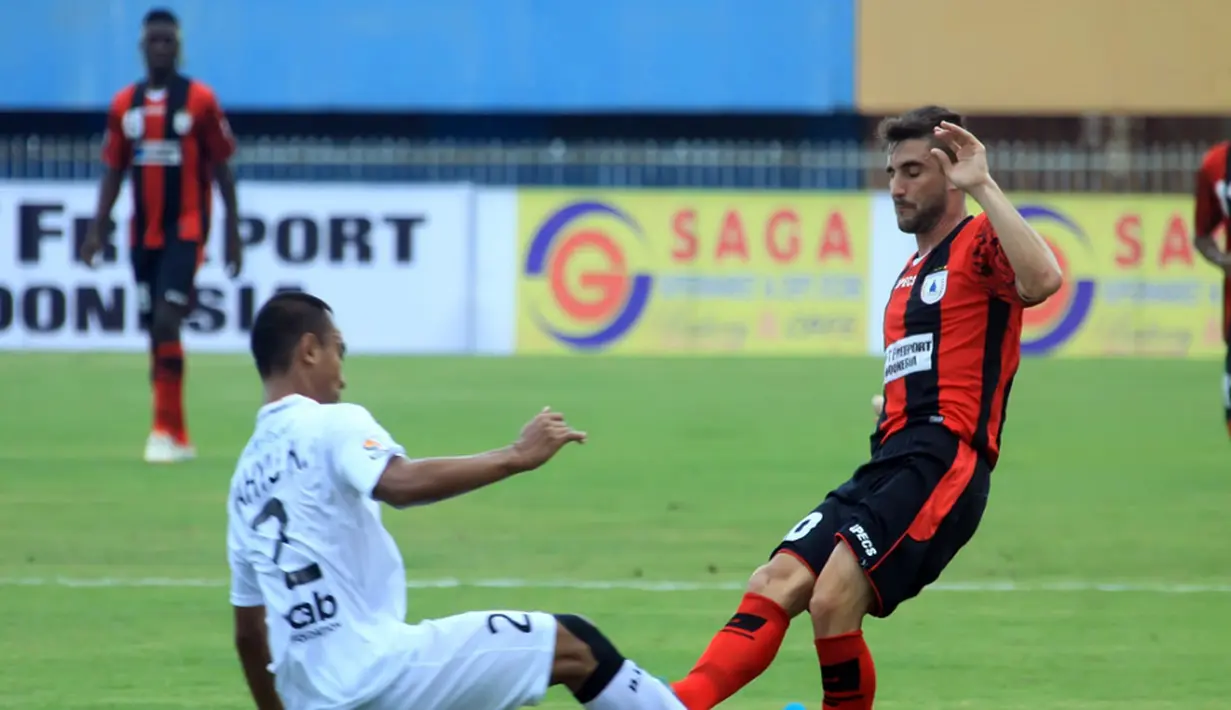 Pemain serbabisa Persipura Robertino Pugliara berduel dengan bek Bali United Wahyu Kristanto. (Liga Indonesia)