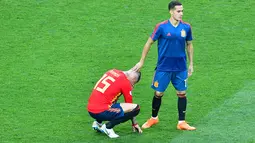 Gelandang Spanyol, Lucas Vazquez menenangkan Sergio Ramos yang menangis usai pertandingan melawan Rusia di babak 16 besar Piala Dunia 2018 di Stadion Luzhniki, Moskow, Rusia (1/7). Spanyol kalah lewat adu penalti atas Rusia 3-4. (AFP Photo/Mladen Antonov)