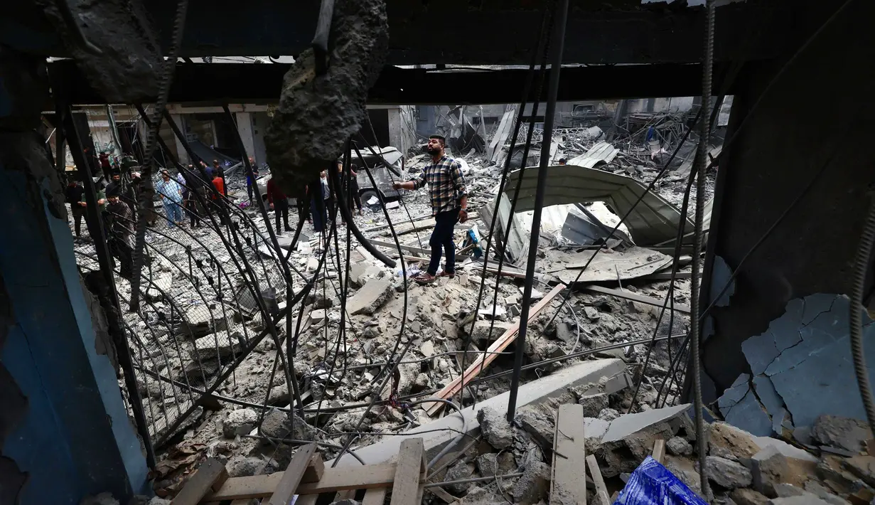 Warga Palestina yang mengungsi memeriksa kerusakan setelah sebuah rumah menjadi sasaran serangan Israel di kamp pengungsi Maghazi, Jalur Gaza Tengah pada Kamis 21 Mei 2026. (Eyad Baba/AFP)