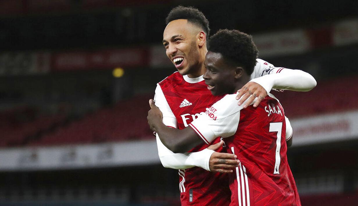 Pemain Arsenal, Bukayo Saka, merayakan gol bersama Pierre-Emerick Aubameyang, usai mencetak gol ke gawang Newcastle United pada laga Liga Inggris di Stadion Emirates, Senin (18/1/2021). Arsenal menang dengan skor 3-0. (Catherine Ivill/Pool via AP)