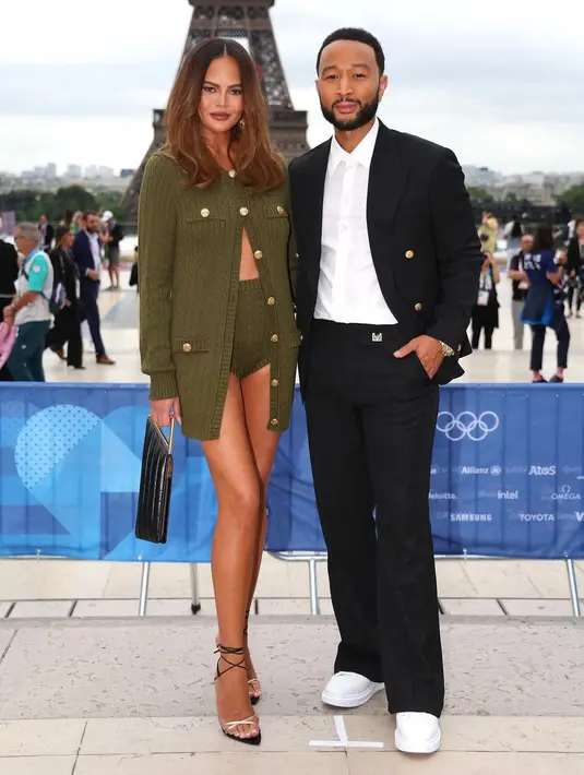 Chrissy Teigen dan John Legend terlihat bersama di upacara pembukaan. Chrissy tampil dengan one set kardigan rajut dan celana super pendek warna hijau olive. [@chrissyteigen]