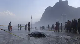 Korban tewas akibat terjatuh setelah bangunan runtuh akibat diterjang ombak di Rio de Janeiro , Brasil , 21 April 2016. Dua orang ini sebelumnya mengambang dilautan sebelum ditemukan oleh petugas. (REUTERS / Ricardo Moraes) 