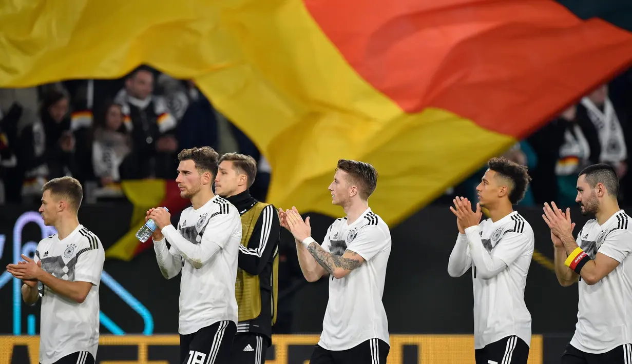 Para pemain Jerman memberikan aplaus kepada suporter usai pertandingan melawan Serbia pada laga persahabatan di Stadion Volkswagen, Rabu, (20/3). Jerman ditahan imbang 1-1 oleh Serbia. (AFP/John Macdugall)