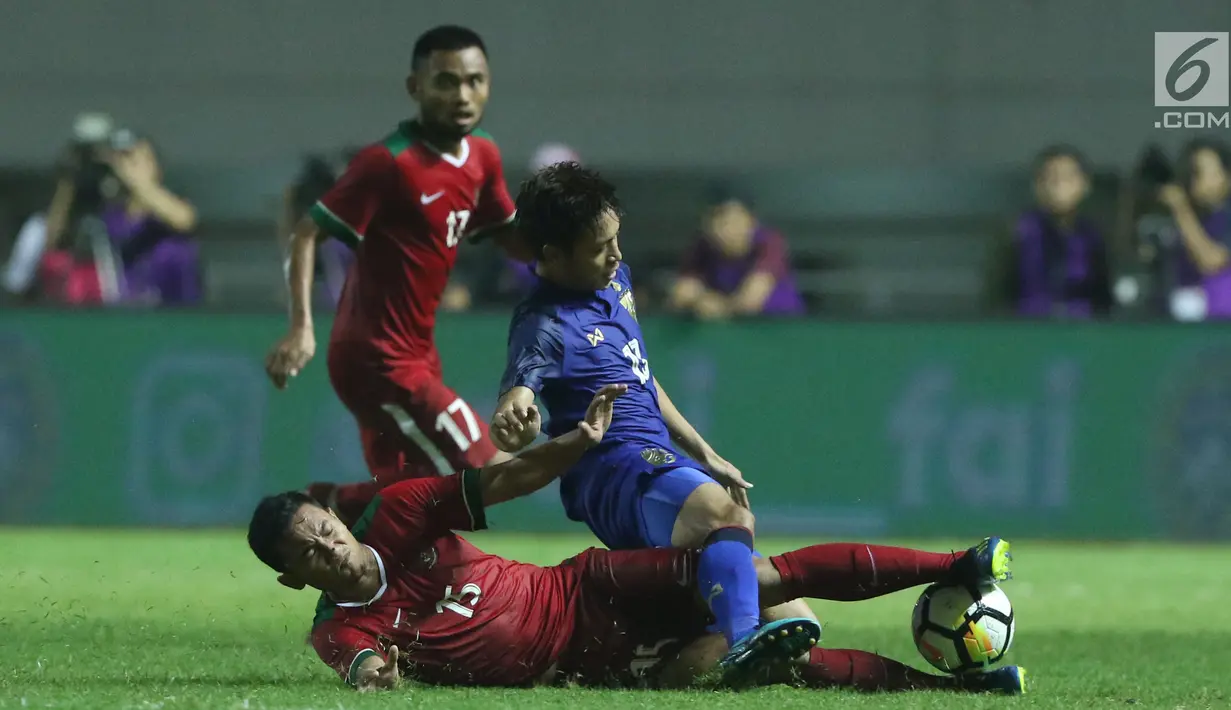 Bek Timnas Indonesia U-23, Ricky Fajrin (bawah) menahan pergerakan pemain Thailand U-23, Picha Au-Tra pada laga persahabatan di Stadion Pakansari, Kab Bogor, Minggu (3/6). Laga berakhir imbang 0-0. (Liputan6.com/Helmi Fithriansyah)