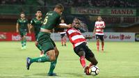 Bek tengah PS Tira, Radanfah Abu Bakr, berduel dengan striker Madura United, Greg Nwokolo, dalam laga lanjutan Liga 1 2018 di Stadion Gelora Ratu Pamelingan, Pamekasan, Jumat (3/8/2018). (Bola.com/Aditya Wany)