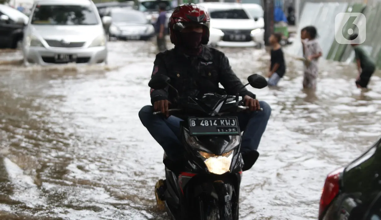 Pengendara sepeda motor menerobos sebagian Jalan Bungur Besar Raya yang tergenang air, Jakarta, Selasa (18/1/2022). Genangan air membuat arus lalu lintas di sekitar depan PN Jakarta Pusat menjadi terganggu dan tersendat. (Liputan6.com/Helmi Fithriansyah)