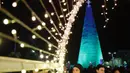 Orang-orang berkumpul di sekitar Pohon Natal raksasa yang terbuat dari botol plastik di kota Chekka, Lebanon, 15 Desember 2019. Sebanyak 129 ribu botol plastik ditata untuk menjadi pohon Natal setinggi 28.5 meter.  (Ibrahim CHALHOUB/AFP)