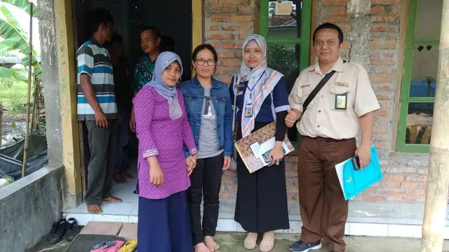 Parinah berfoto bersama dengan petugas P4TKI dan BNP2TKI seusai tiba di rumah anak perempuannya, Sunarti, di Nusawungu, Cilacap. (Foto: Liputan6.com/Muhamad Ridlo)